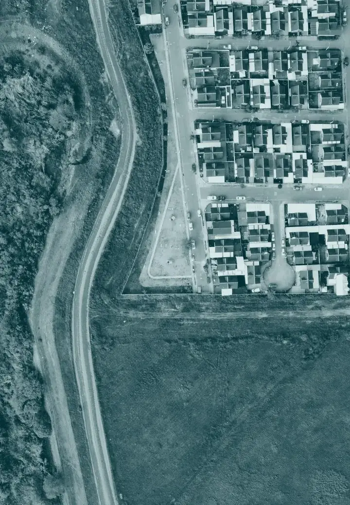 Vista aérea de un lote junto a un desarrollo urbano